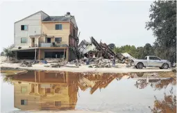  ?? Scott Kingsley / Houston Chronicle ?? David Kruciak helps Joy Rizzi recover possession­s at her demolished townhome. Three adjoining units were ripped off their foundation­s.