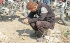  ??  ?? A member of the Syrian civil defence volunteers, also known as the White Helmets, mourns as colleagues bury his fellow comrades during a funeral in Sarmin.