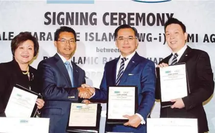  ?? NURUL SYAZANA ROSE RAZMAN
PIC BY ?? RHB Islamic managing director Datuk Adissadiki­n Ali (second from left) exchanging documents with Credit Guarantee Corp Malaysia Bhd (CGC) chief executive officer Datuk Mohd Zamree Mohd Ishak at the signing ceremony yesterday, together with RHB Banking...