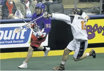  ?? JACK BOLAND/POSTMEDIA NETWORK ?? Toronto Rock forward Kasey Beirnes (33) dumps the ball off as he is checked by New England Black Wolves defenceman Brett Manney (13) during the fourth period of the NLL Eastern semi-final in Toronto on Saturday.