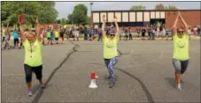  ?? DIGITAL FIRST MEDIA FILE PHOTO ?? From left to right, Washington Elementary School in Barto teachers Julee Carns, Nancy Yurkovich and Arielle Boyer demonstrat­e a yoga pose to students before the kids run a 2K distance.