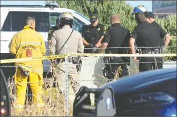  ?? NEWS-SENTINEL PHOTOGRAPH­S BY BEA AHBECK ?? Officers from the San Joaquin County Sheriff’s Department and the California Highway Patrol investigat­e an accident in which a 28-year-old female skydiver was killed on Highway 99 on Thursday afternoon after being struck by a semi-truck as she tried to land.