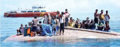  ?? — AFP photo ?? Rohingya refugees waiting to be rescued from the hull of their capsized boat as a National Search and Rescue Agency (BASARNAS) vessel approaches in waters off west Aceh.