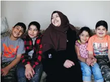  ??  ?? Syrian refugee and single mom, Fatima al-Rajab, at her home in Calgary with her children Mourad, 6, left, Hanadi, 11, Amani, 8 and Ahmed, 10, has been in Canada over a year now, and sometimes feels like going home.