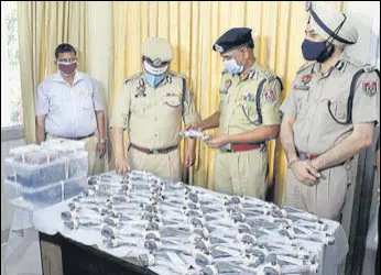  ?? SAMEER SEHGAL /HT ?? ADGP (internal security) RN Dhoke (C), Amritsar police commission­er Sukhchain Singh Gill (right) and police officials with the seized pistols and ammunition in Amritsar on Friday.