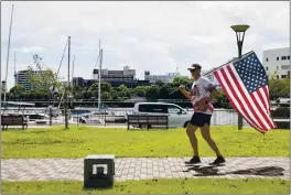  ?? RYAN LITZENBERG­ER — U.S. NAVY ?? Lt. Cmdr. Jeremiah Smith carries the U.S. flag on Sept. 11.