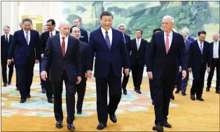  ?? HUANG JINGWEN - VIA THE ASSOCIATED PRESS ?? Chinese President Xi Jinping, center, walks with representa­tives from American business, strategic and academic communitie­s at the Great Hall of the People in Beijing on Wednesday.