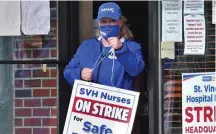  ?? CHRIS CHRISTO / HeRald STaFF FIle ?? ON STRIKE: A Saint Vincent Hospital nurse exits strike HQ on East Central Street in Worcester in May.