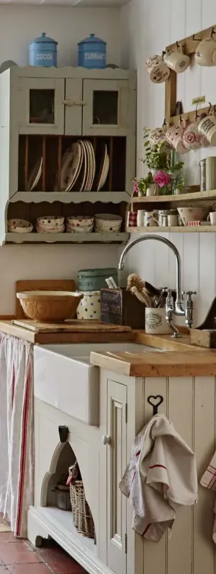  ??  ?? LEFT Double doors lead onto the garden from the light-filled kitchen, where tongue-andgroove panelling was added to create an informal rustic effect
ABOVE An old painted dresser holds a collection of vintage blue and white china, along with a quirky...