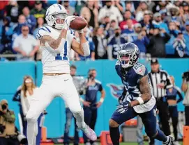  ?? George Walker IV/Associated Press ?? Colts receiver Michael Pittman Jr., left, corralled a 4-yard touchdown in overtime as Indianapol­is kept its hold on the final AFC wild-card spot by beating the Titans.