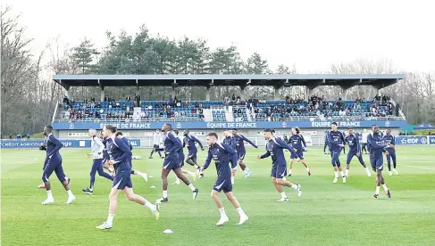  ?? — Gambar AFP ?? PANASKAN BADAN: Skuad bola sepak lelaki Perancis menjalani sesi latihan sebagai persediaan untuk perlawanan persahabat­an yang akan datang.