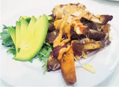  ?? ?? Upscale’s Chicken and Avocado Melt over potato wedges, bacon and arugula.