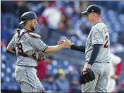  ??  ?? Catcher Bryan Holaday congratula­tes Brad Ziegler on his first save of the season. Ziegler pitched the ninth inning and allowed one hit as the Marlins beat the Phillies 6-3.