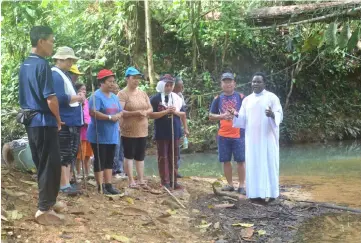  ??  ?? Fr Mathews (right) leads a prayer prior to their journey home after visiting the Tagang system.