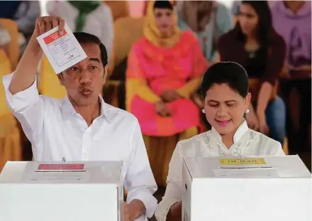  ??  ?? Indonesian President Joko Widodo and his wife Iriana casting their votes during the general election in Jakarta on April 17. He swept back into a second term but not without having to resist rather strong political headwinds from retired General Prabowo Subianto.