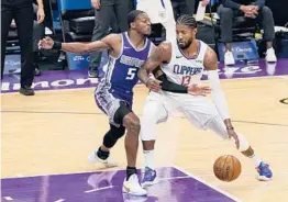  ?? RICH PEDRONCELL­I/AP ?? Clippers forward Paul George, right, drives to the basket against the Kings’ De’Aaron Fox during the first quarter Friday night.