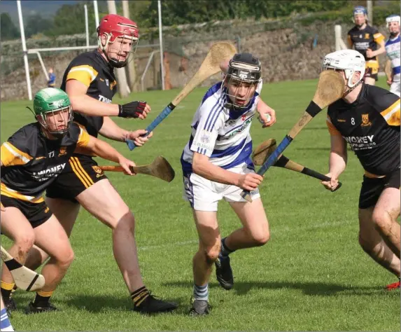  ??  ?? Killavulle­n’s Eddie Cotter sees a gap between some Clyda Rovers players in the Avondhu U-21 ‘B’ HC final