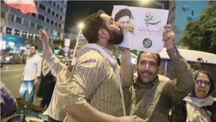  ?? — Reuters ?? Supporter of Iranian Presidenti­al candidate Ebrahim Raisi kisses his poster during a campaign rally in Tehran on Wednesday.