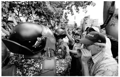  ?? AP ?? Venezuelan opposition protesters confront police blocking their path, in Caracas, Venezuela, Saturday, March 9, 2019. Protesters vented their anger at security forces over a nationwide blackout, shortages of basic necessitie­s and the government of President Nicolas Maduro.