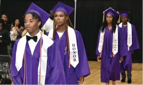  ?? ?? From left, Kenneth Moore, DyZharia Hawkins, LaParis Harris and Marc Thompson march to the “Pomp and Circumstan­ce” music to begin graduation.