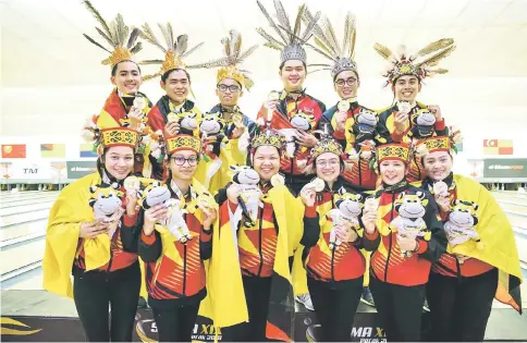  ??  ?? Sarawak bowling team celebrate on the podium at Ampang Superbowl yesterday. — Photo by Ng Joon Si