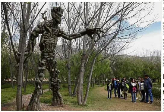  ?? — AP ?? Movie magic: Visitors standing near a sculpture of Groot, a Marvel superhero, at a public wetland in Cuzco, Peru.