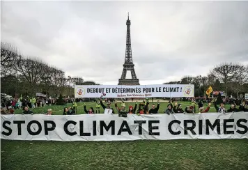  ?? | EPA ?? THOUSANDS of people demonstrat­e in front of the Eiffel Tower to raise awareness about climate change in Paris, France.