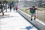  ?? Marcus Yam Los Angeles Times ?? SARA IXCOY walks beside a fenced-off area at Lorena Street Elementary, which has contaminat­ed soil.