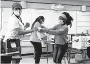  ?? BRIAN CASSELLA/CHICAGO TRIBUNE ?? Senior council members Symphene Destin, from left, Unika Valentine and Essi Adokou put together gift bags Tuesday as they prepare for their upcoming graduation at Baker College Prep in South Chicago.