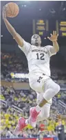  ?? CARLOS OSORIO/AP PHOTO ?? Michigan guard Muhammad-Ali Abdur-Rahkman drives for two of his 6 points Sunday in a 62-47 win over Rutgers in Ann Arbor, Mich.