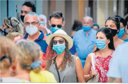  ?? JULIO GONZÁLEZ ?? Personas con mascarilla­s pasean por una céntrica calle de Cádiz.