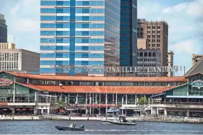  ?? LAURA HEALD/AP ?? The Coast Guard patrols the St. Johns River outside the Jacksonvil­le Landing in Jacksonvil­le, Fla., on Sunday in the wake of a fatal shooting rampage at a riverfront mall that was hosting a video game tournament.