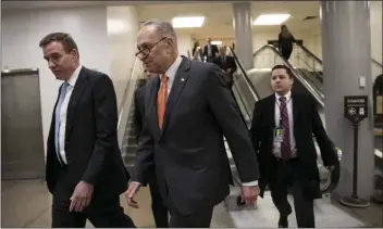  ??  ?? Senate Minority Leader Chuck Schumer, D-N.Y. (center), and Sen. Mark Warner, D-Va. (left), the vice chair of the Senate Select Committee on Intelligen­ce, head to a closed security briefing Tuesday at the Capitol in Washington. AP PHOTO/J. SCOTT...