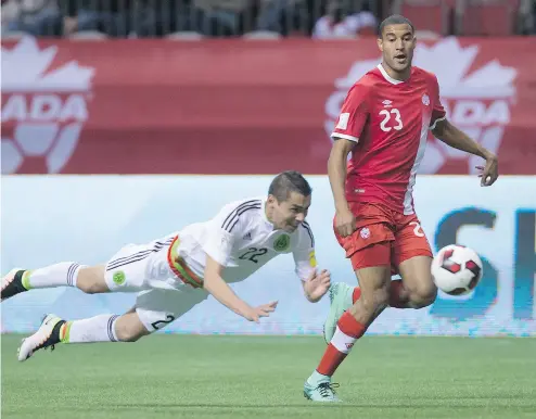  ?? DARRYL DYCK / THE CANADIAN PRESS ?? Mexico’s Paul Aguilar, left, dives to try to stop Canada’s Tesho Akindele during FIFA World Cup qualifying action last year. There’s talk of a North American bid including the U. S., Canada and Mexico for the 2026 World Cup.