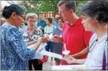  ?? CHRISTINE WOLKIN — FOR DIGITAL FIRST MEDIA ?? Members of the community light candles at the vigil for the victims of the violence in Charlottes­ville, Sunday, Aug. 20.