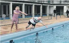  ??  ?? Veteran swimmer Bill Marriott (76) pushes former council leader John Peach into the pool to mark the opening of the 2021 swimming season.