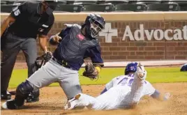  ?? NUCCIO DINUZZO/GETTY IMAGES ?? Willson Contreras scores ahead of the tag of Brewers catcher Omar Narvaez in the sixth inning at Wrigley Field.