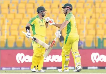  ?? — AFP ?? Australia’s Marcus Stoinis (R) and team-mate Matthew Wade bump their fists after beating South Africa in the ICC T20 World Cup Group I match at the Sheikh Zayed Cricket Stadium in Abu Dhabi.