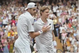  ?? AP PHOTOS ?? HISTORIC DAY: American John Isner (above, left) congratula­tes Kevin Anderson after the South African’s marathon five-set victory yesterday at Wimbledon, setting the record for the longest semifinal in the tournament’s 132-year history (scoreboard below).