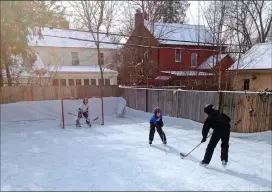  ?? John Rubin photo via AP ?? In this January 2013 photo, members of the Rubin family are shown playing hockey on their backyard ice rink in the Burns Park neighbourh­ood of Ann Arbor, Mich.