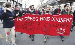  ??  ?? PARIS: People hold a banner reading “Borders divide” and calling for “freedom of movement and residence” during a demonstrat­ion in support of migrants and refugees in Paris yesterday. — AFP