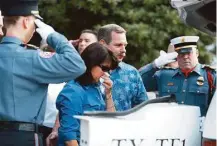  ?? Karen Warren / Houston Chronicle ?? Firefighte­rs, with black bands on their badges, salute as Denise and Randy Corliss take their final walk with Bretagne.