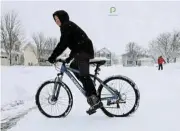  ?? /Reuters ?? Balancing act: Conley Davis, 12, tries to ride his bicycle in the snow after a winter storm in Waukee, Iowa.