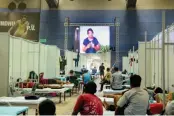  ?? — PTI ?? Patients watch a movie on a screen installed inside a ward at CWG Village in New Delhi on Sunday.