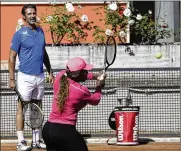  ?? GREGORIO BORGIA / AP ?? Serena Williams returns the ball as her coach Patrick Mouratoglo­u (left) watches her during a training session at the Italian Open tennis tournament, in Rome on Monday.