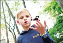  ??  ?? Ten-year-old Louis Wuestenber­g plays with a fidget spinner in a park in New York on May 23. It was supposed to calm nerves, relieve strees and
improve concentrat­ion. (AFP)