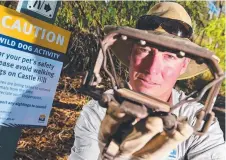  ?? Picture: SCOTT RADFORD- CHISHOLM ?? ON THE PROWL: Council land protection officer Luke Playford with a wild dog trap.