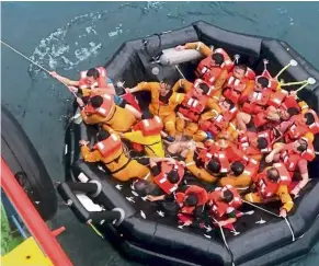  ??  ?? Sea rescue: (Left) Some of the crew from the ‘Dayang Topaz’ were spotted in the sea after the ship was battered by huge waves off Miri, Sarawak. (Right) Rescuees on board a liferaft were saved by another vessel that responded to distress signals following the mishap.