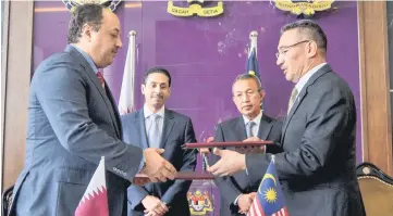  ??  ?? Hishammudd­in (right) and Dr Khalid Mohamad exchange documents after the signing of a Letter of Intent (LOI). Witnessing the exchange are Defence Ministry‘s secretary general Datuk Seri Abd Rahim Mohd Radzi (second right) and Qatari Ambassador to...