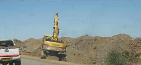  ??  ?? An excavator gets down to business on the shoulders of the Shurugwi-Zvishavane highway